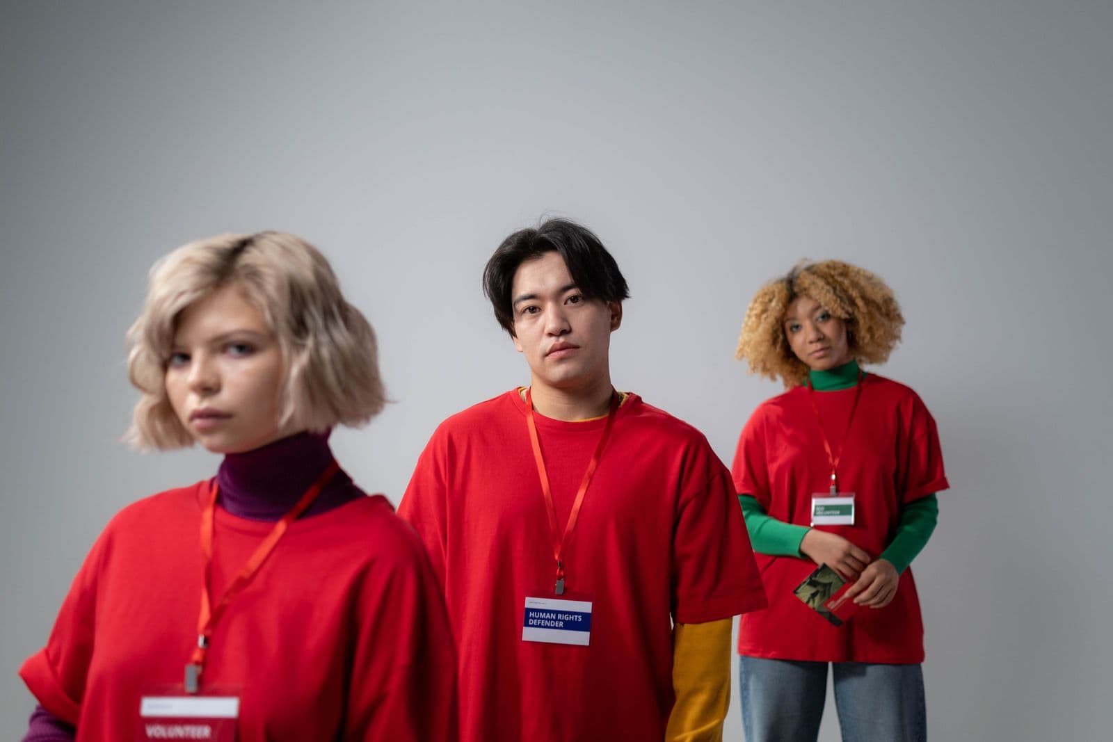 Three volunteers wearing red shirts and name badges