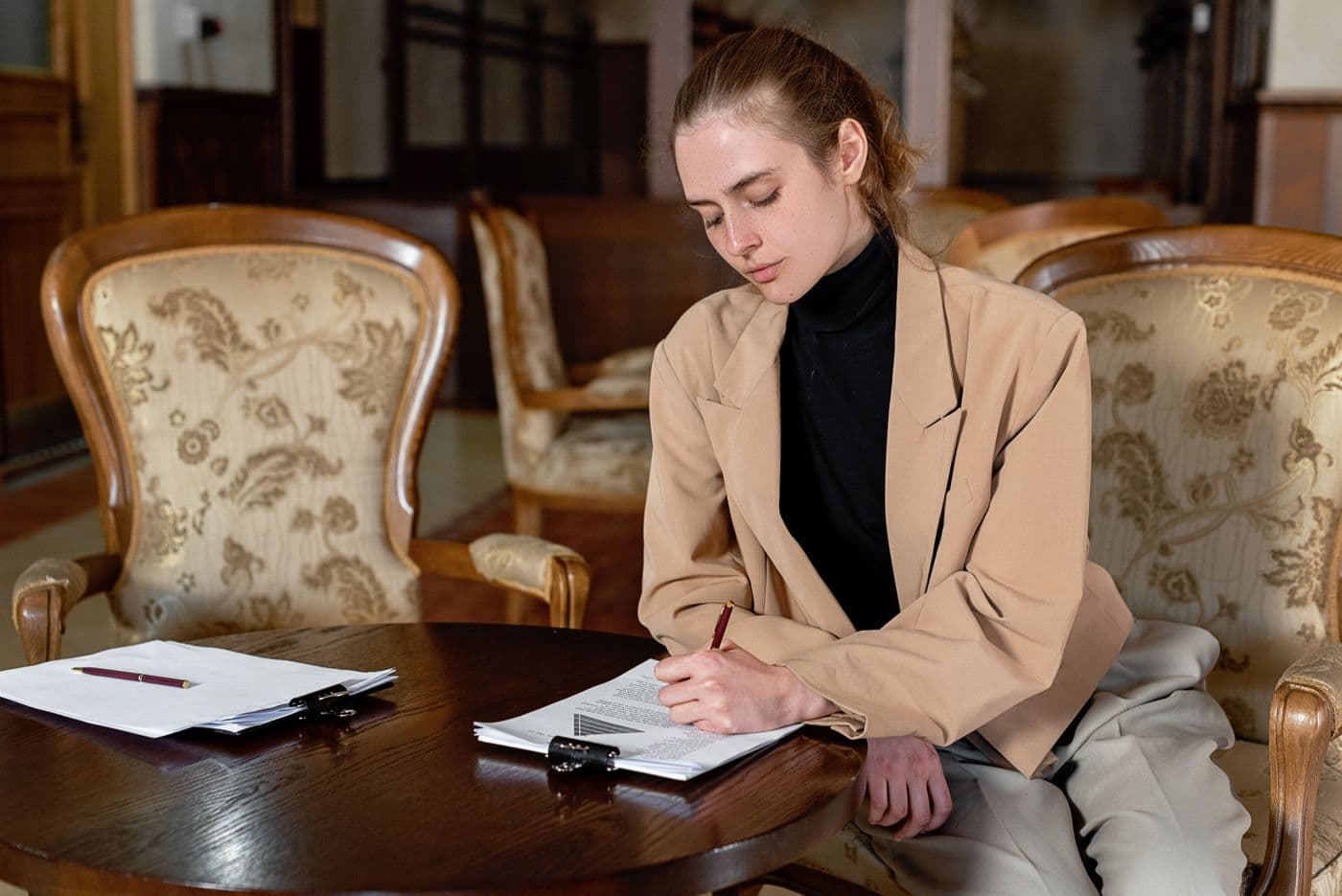 A client signing documents at a notary's desk