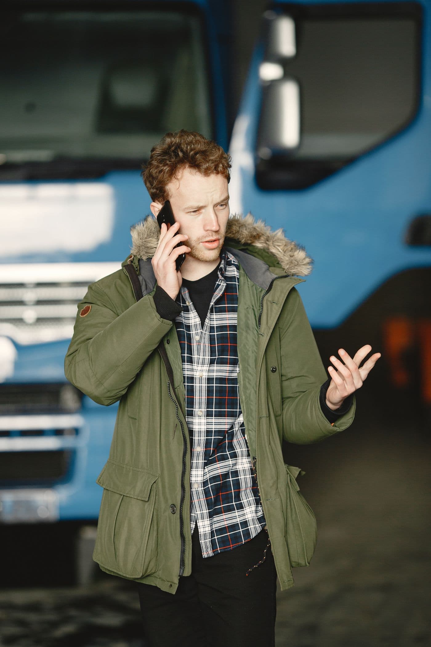 A tradesman taking a call beside his truck